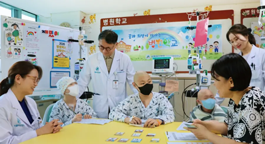 사진 : 서울아산병원 어린이병원학교에서 김혜리 어린이병원학교장, 임호준 어린이병원장(왼쪽 첫 번째, 세 번째)이 자원봉사자 이은정 교사에게 한문수업을 듣고있는 소아암 환아들을 격려하고 있는 모습.