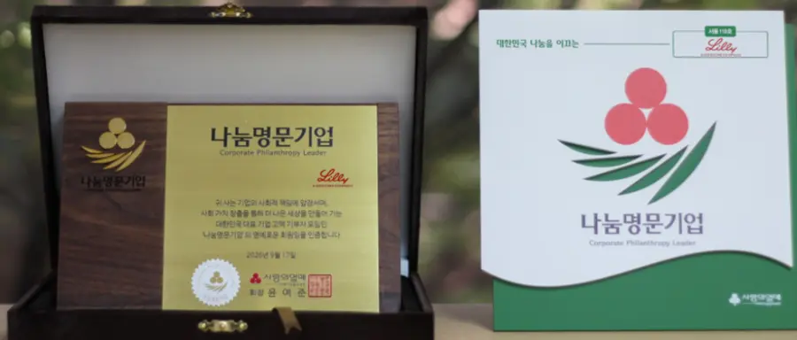 ▲사랑의열매가 한국릴리에 전달한 ‘나눔명문기업’ 현판(왼쪽)과 서울 119호 기념패(오른쪽).